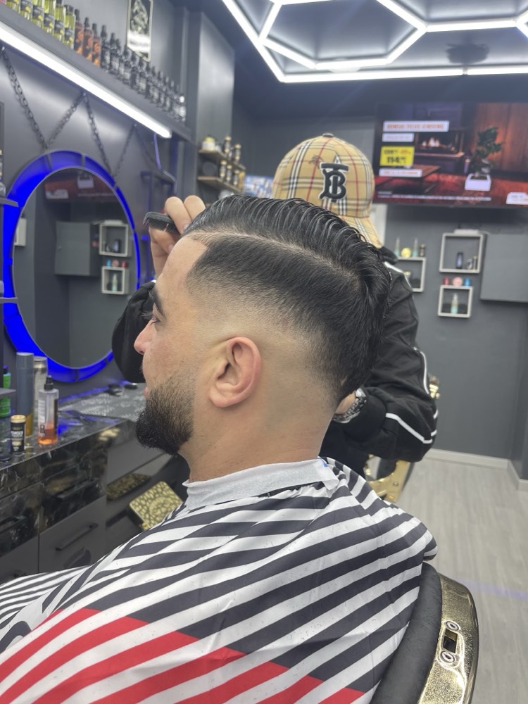 Skin fade con riga e barba curata