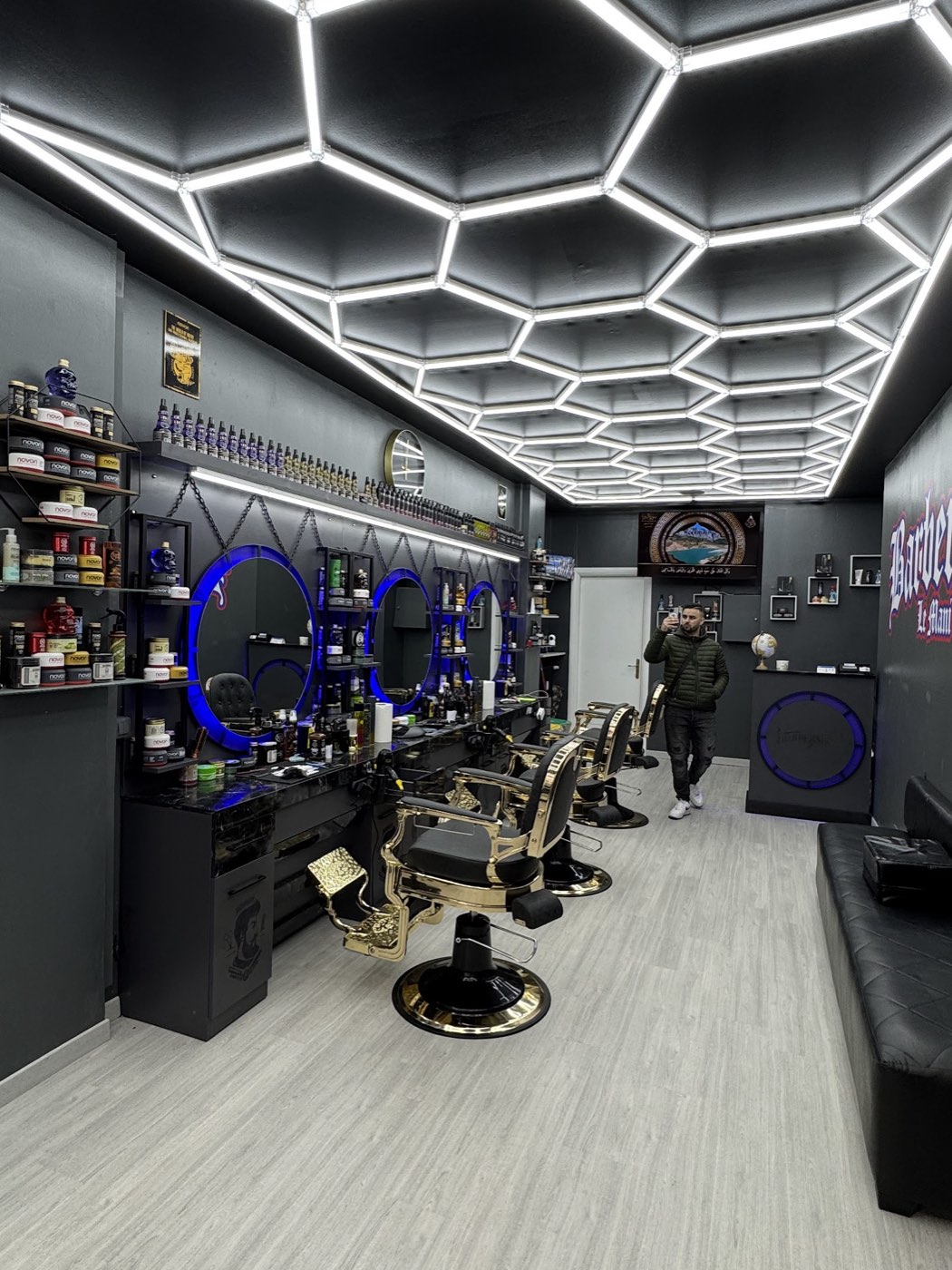 Il salone Le Mani d'Oro: soffitto di luci LED a nido d'ape, pareti nere e poltrone dorate